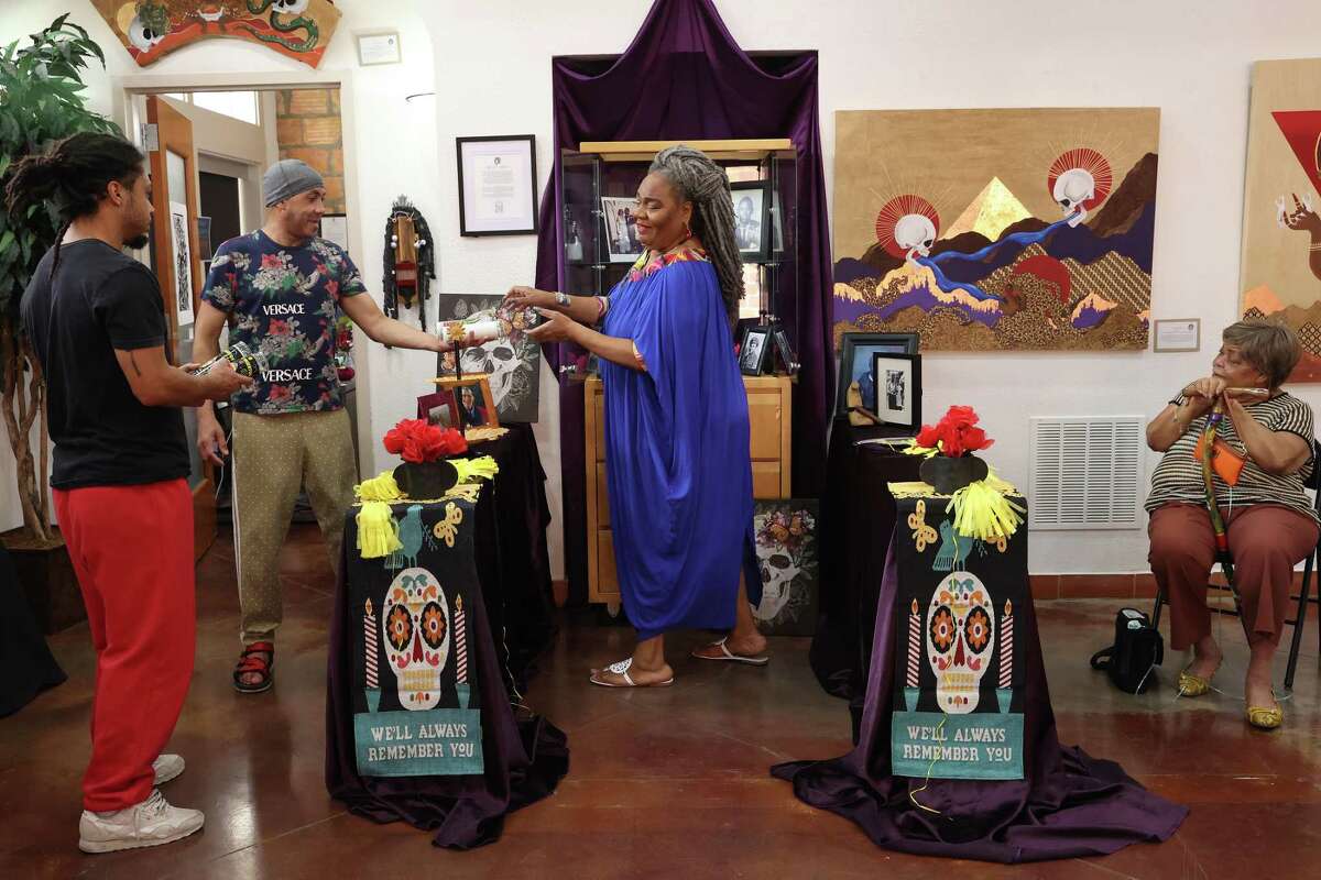 Maria Williams, owner of Eye of the Beholder Art Gallery, center, makes an altar with help from muralist, Joseph Ramey, left, sculptor, Hoi Ellis, second from left, and artist, Claudette Hopkins on Friday. Williams remembers her childhood when her mother observed Dia de los Muertos by building an altar in honor of their Cuban and Panamanian ancestors. After her mother’s death, Williams has continued the tradition, infusing the altars with symbols of her Afro-Latino heritage.