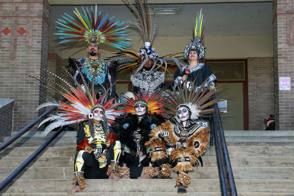 HOUSTON, TX OCT 30: Members of Danza Azteca Taxcayolotl pose on the building’s steps during the MECA's 22nd Annual Dia De Muertos Festival, which features music and dance performances, vendors, food ,and ofrendas at the Dow School in Houston, Texas.