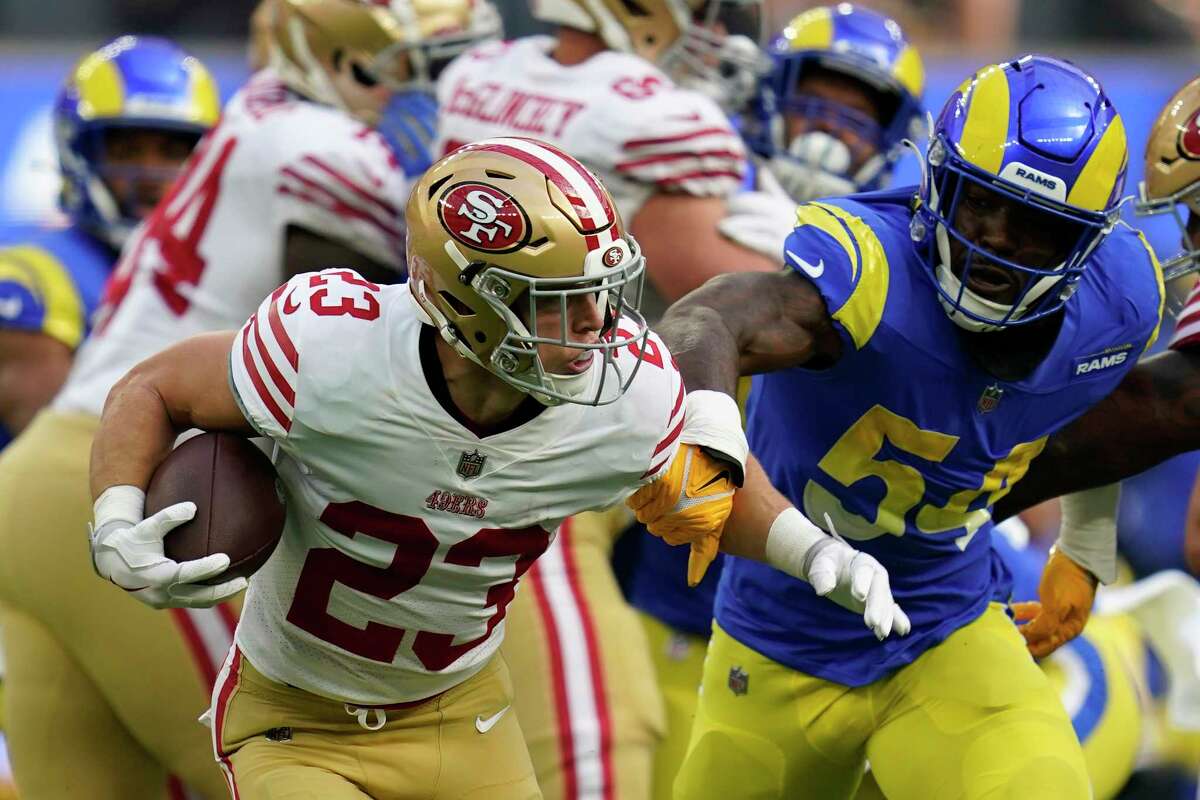 San Francisco 49ers running back Christian McCaffrey, left, avoids a tackle by Los Angeles Rams linebacker Leonard Floyd during the first half of an NFL football game Sunday, Oct. 30, 2022, in Inglewood, Calif. (AP Photo/Ashley Landis)