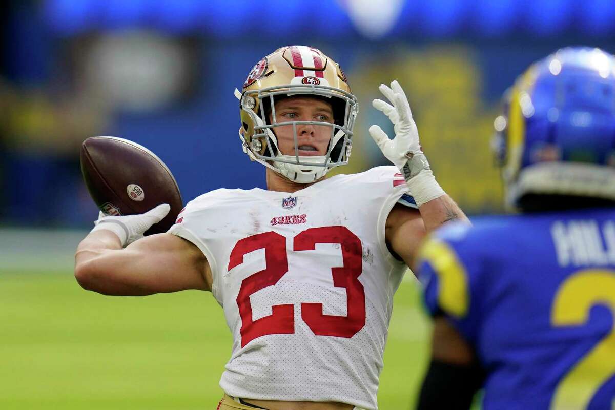 San Francisco 49ers running back Christian McCaffrey, left, passes for a touchdown on a trick play as Los Angeles Rams cornerback Troy Hill watches during the first half of an NFL football game Sunday, Oct. 30, 2022, in Inglewood, Calif. (AP Photo/Gregory Bull)