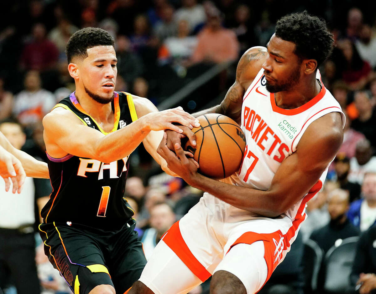 Phoenix Suns' Devin Booker (1) and Houston Rockets' Tari Eason (17) battle for the ball during the first half of an NBA basketball game, Sunday, Oct. 30, 2022, in Phoenix. (AP Photo/Darryl Webb)