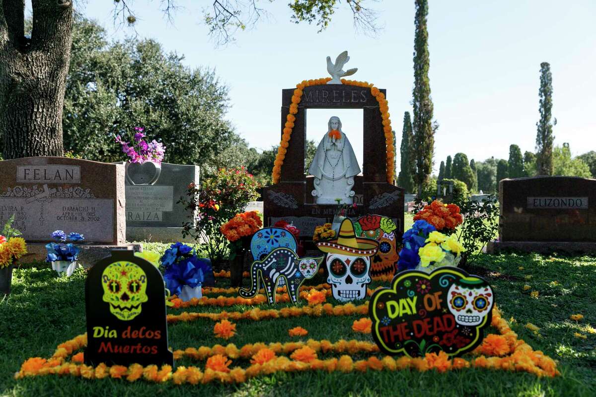 Marigolds and Dia de los Muertos signs cover a gravesite in San Fernando Cemetery II on Oct. 30, 2021. “We celebrate Día De Los Muertos because we know we are alive — and because we love our traditions,” writes Rafael Castillo.