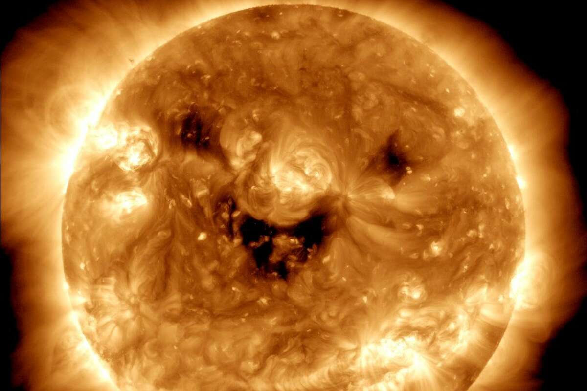 The NASA Solar Dynamics Observatory caught the sun 'smiling.' These dark patches resembling a grin and eyes are known as coronal holes and are regions where fast solar wind gushes out into space.