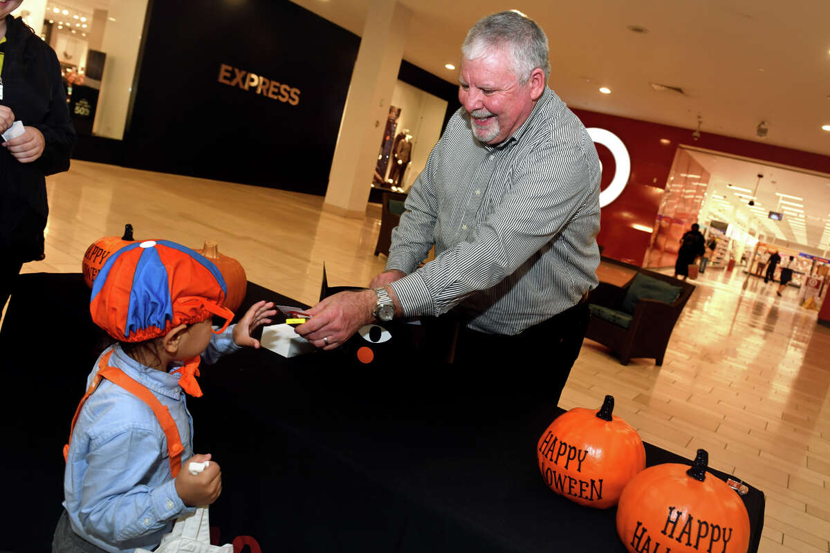 Mall vice president Patrick Madden hands out candy to trick-or-treaters on Halloween at Westfield Trumbull, in Trumbull, Conn. Oct. 31, 2022.
