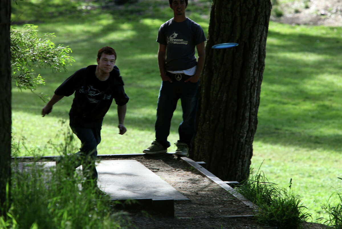 Eric Dettmann (left) throws to disc golf basket #16 at the disc golf course in Golden Gate Park in San Francisco, California on May 24, 2010. Travis Rybiski (right), from Millbrae, waits his turn.