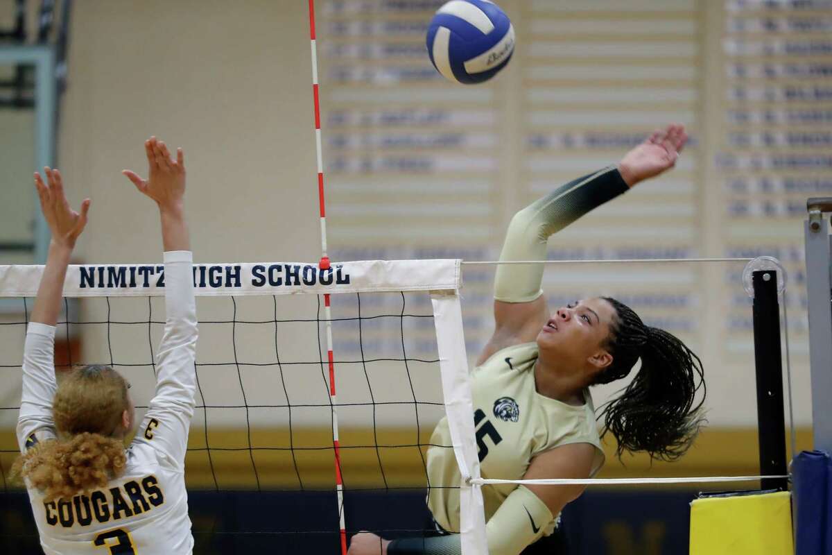 Conroe's Ariana Brown, right, spikes against Nimitz, left, during their Region II-6A bi-district volleyball match at Nimitz High School Monday, Oct. 31, 2022 in Houston, TX.