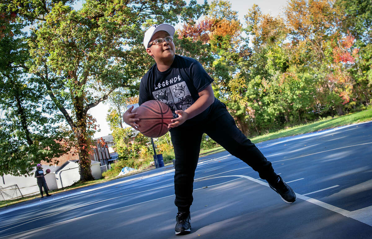 Robert Carmon shows off his basketball skills at the court off Glade Street near his West Haven home. His asthma has improved since he was diagnosed as an infant.