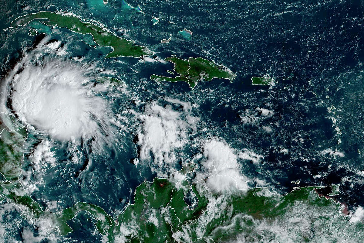 This satellite image taken at 8:40am ET and provided by NOAA shows Tropical Storm Lisa under Cuba in the Caribbean Sea, Tuesday, Nov. 1, 2022. Lisa is forecast to make landfall in Central America later in the week as a likely hurricane. (NOAA via AP)