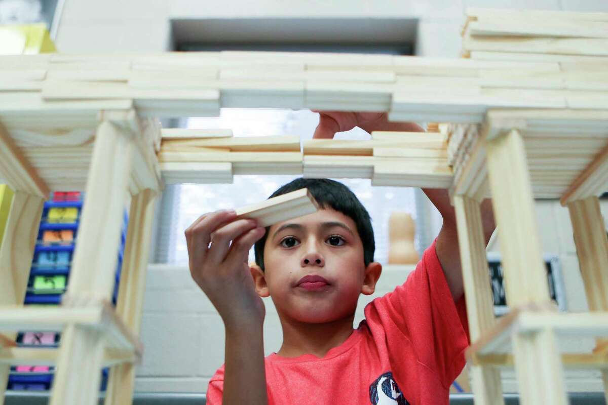 Wilkinson Elementary School fourth grader Foster Perdue builds a bridge using Keva Planks at Megan Gaskin’s Science, Technology, Engineering, and Math class, Tuesday, Nov. 1, 2022, in Conroe. Gaskin sent images of Perdue’s bridge to the civil engineering department at Texas A&M, who sent him a care package to encourage him.
