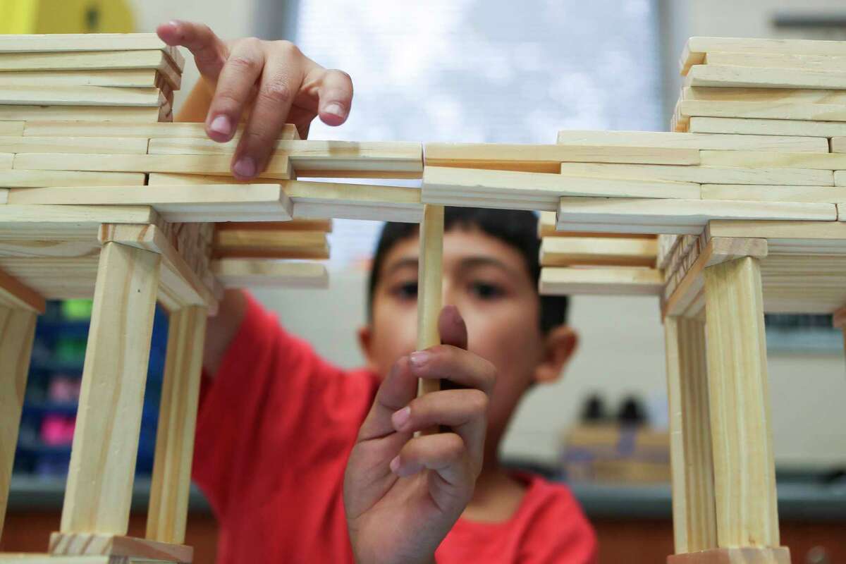 Wilkinson Elementary School fourth grader Foster Perdue moves a Keva Plank into place as he builds a bridge at Megan Gaskin’s Science, Technology, Engineering, and Math class, Tuesday, Nov. 1, 2022, in Conroe. Gaskin sent images of Perdue’s bridge to the civil engineering department at Texas A&M, who sent him a care package to encourage him.