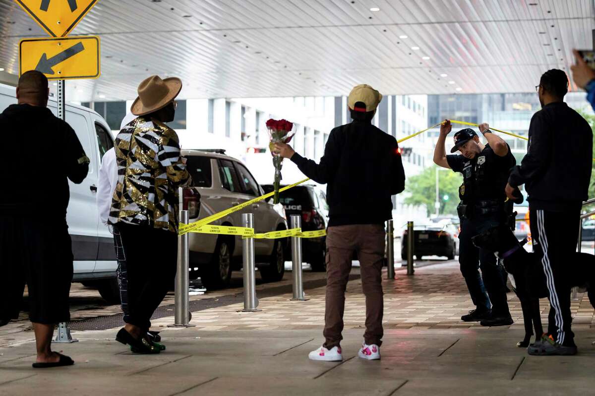 Police move fans away from the sidewalk as they prepare to wheel a body into a medical examiners' van outside 1201 San Jacinto following a shooting Tuesday, Nov. 1, 2022. The rapper Takeoff, best known for his work with the Grammy-nominated trio Migos, died after a shooting early Tuesday outside of 810 Billiards & Bowling in Houston, a representative confirmed. He was 28. (Annie Mulligan/Houston Chronicle via AP)