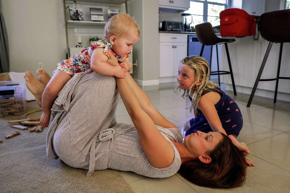 Geri Landman plays with daughters Lucy and Edna in August. On her good days, Lucy is alert and eager to interact with her older sisters. When she’s tired or sick she can be inconsolably fussy.