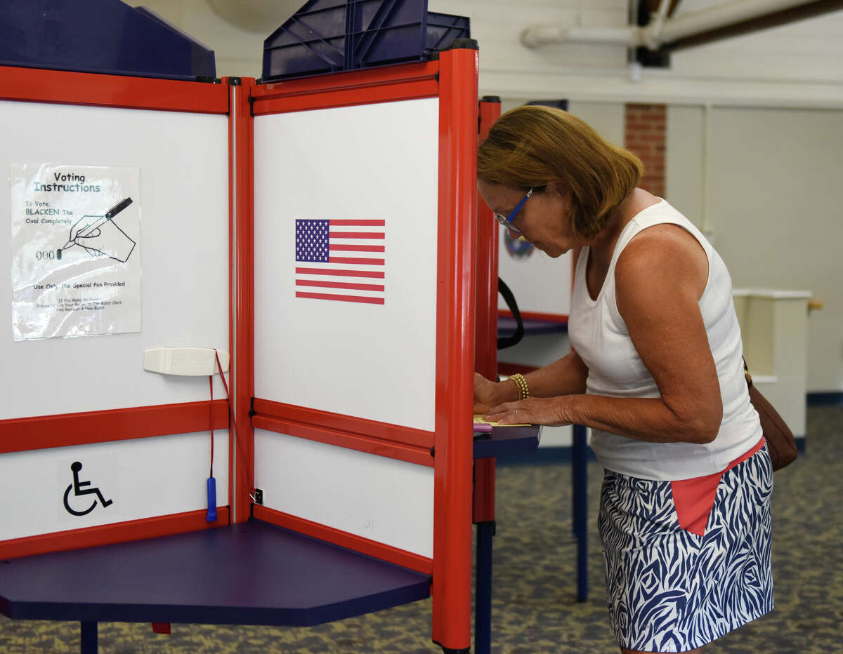 A voter fills out their ballot at the Darien Board of Education, which is the District 1 polling center, in Darien, Conn. Tuesday, Aug. 9, 2022.