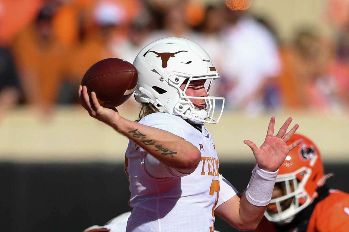 Texas quarterback Quinn Ewers, left, looks to throw a pass during the first half of an NCAA college football game against Oklahoma State, Saturday, Oct. 22, 2022, in Stillwater, Okla. (AP Photo/Brody Schmidt)