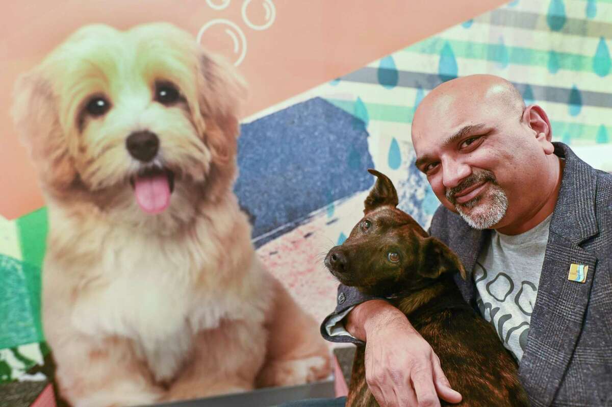 Deven Bhakta, owner of Dogtopia, enjoys a moment with his dog, Kallie, at the dog day care.