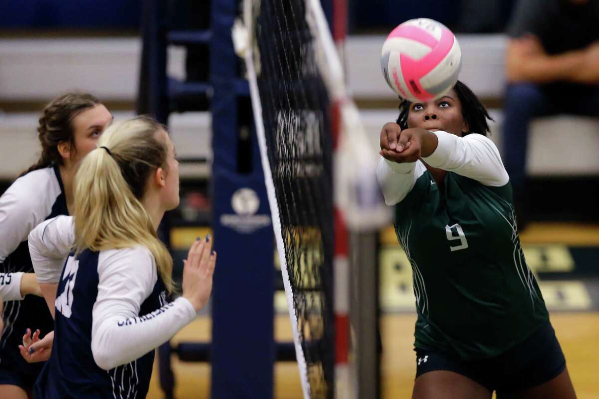 Spring's Ka'Lisa Keller (9) gets the volley over the net as College Park's Sophia Lucario, left, and Cassidy Copeland, middle, look on during their Region II-6A bi-district volleyball match at College Park High School Tuesday, Nov. 1, 2022 in The Woodlands, TX.