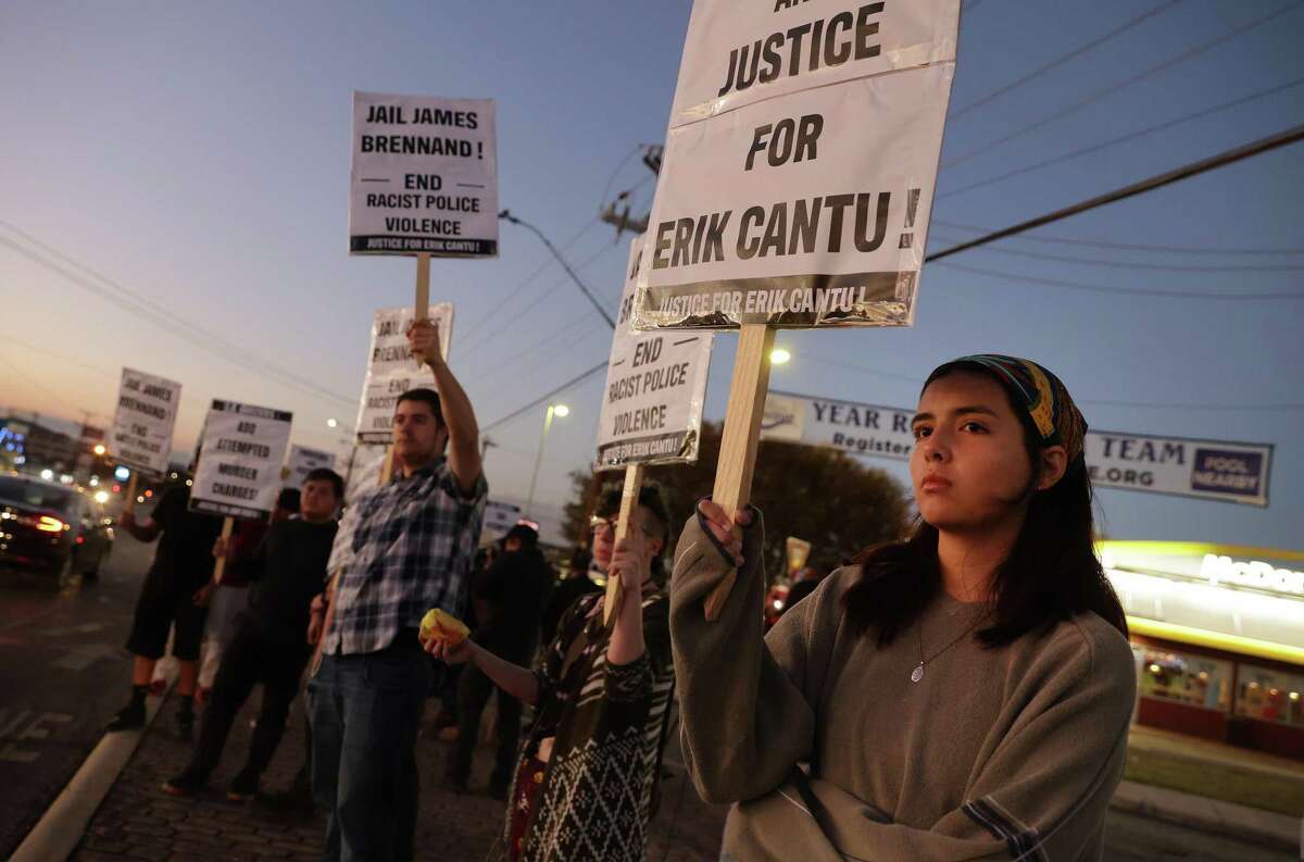 Lylia Lopez, right, joins the group Party for Socialism and Liberation San Antonio as they gather Tuesday evening for a vigil near Blanco Road and West Avenue near where Erik Cantu was shot on Oct. 2 by now-fired San Antonio police officer James Brennand.