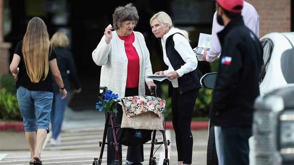 Ann Snyder, third from left, helps a woman before casting her ballot at the South Montgomery County Community Center, Wednesday, Nov. 2, 2022, in The Woodlands.