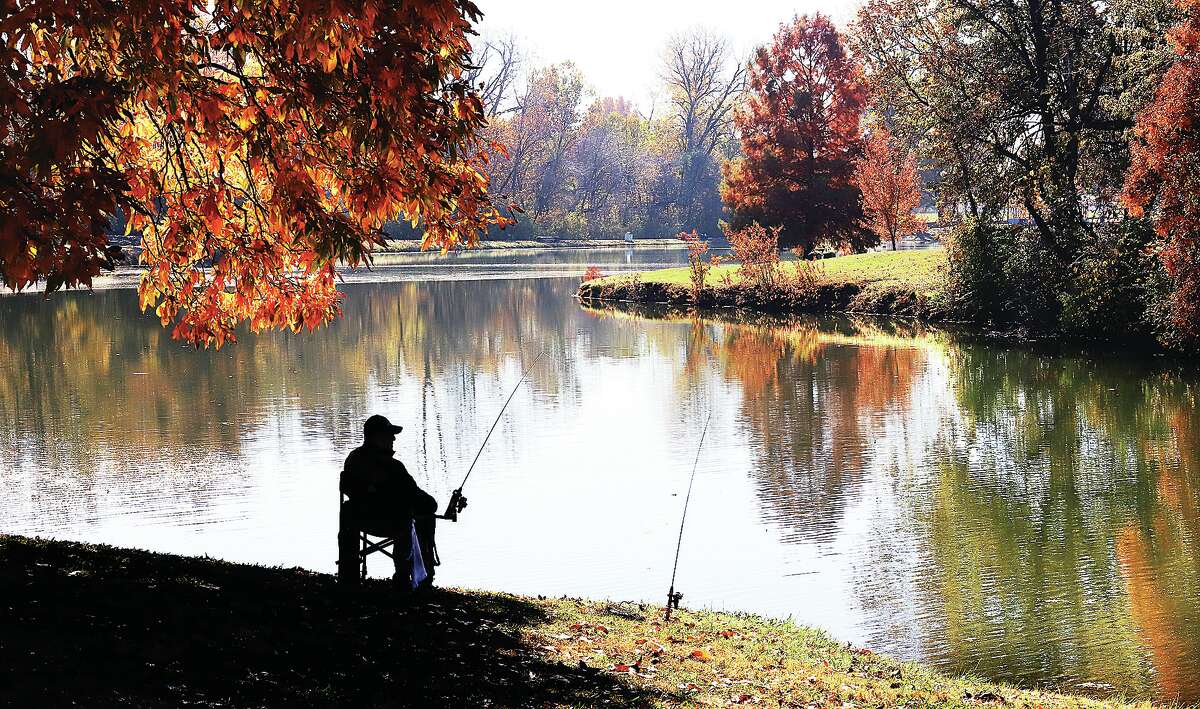 John Badman|The Telegraph A man enjoys the peace of fishing under the fall colors this week in Wood River's Belk Park. The area is enjoying unseasonably warm November weather in the mid to upper 70's which will continue through the work week before cooling back into the 60s for the weekend.