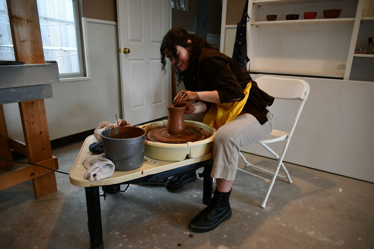 Lesley Klay forms a clay vase on a pottery wheel.