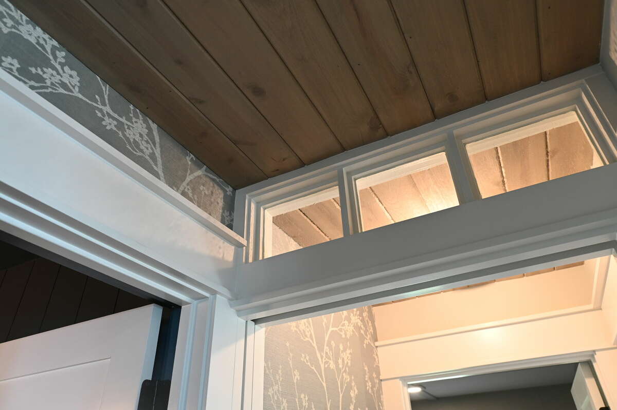 The pocket door built to provide more privacy in the guest bedrooms is topped with an old-style transom window.
