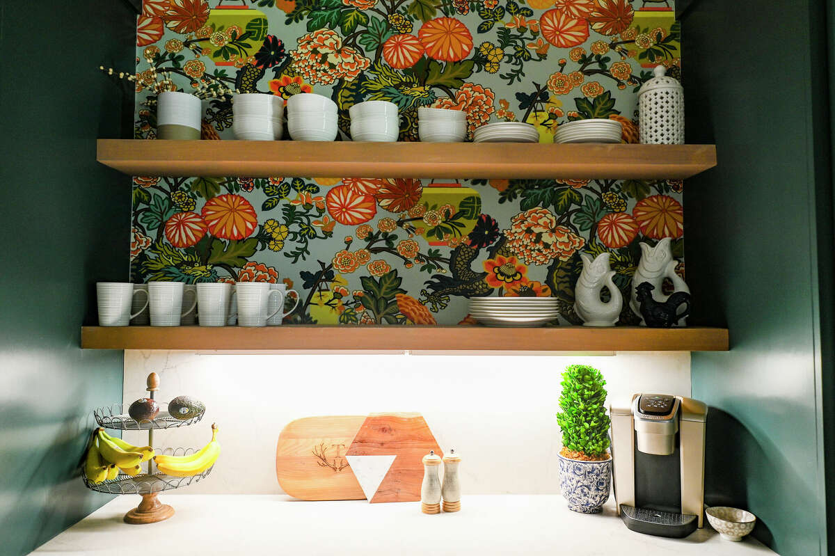 Almost every surface throughout the house has a different design touch or texture, such as the wallpaper behind this open shelving.