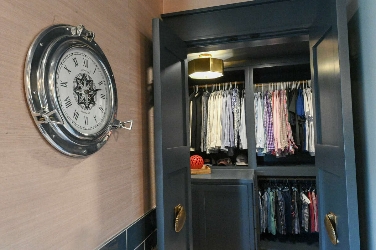 The large walk-in closet is visible in the background with a porthole clock in the foreground.
