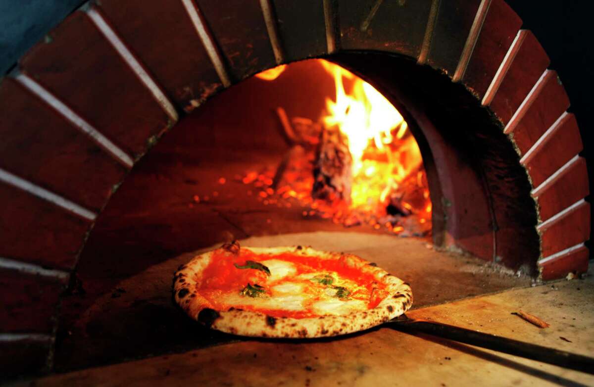A margherita pizza made with buffalo mozzarella cheese emerges from the wood-fired brick oven at Zero Zero in 2010.