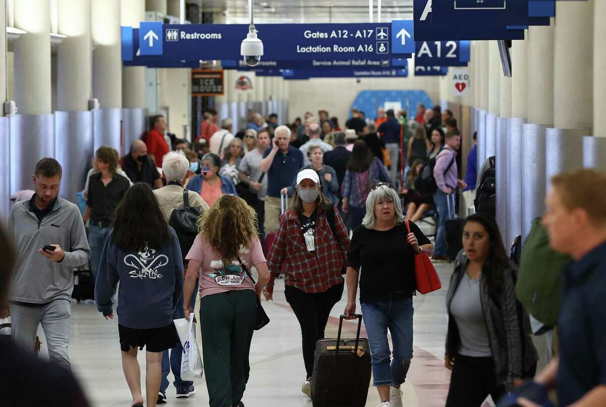 Travelers walk inside Terminal A at the San Antonio International Airport on Wednesday, Oct. 12, 2022.