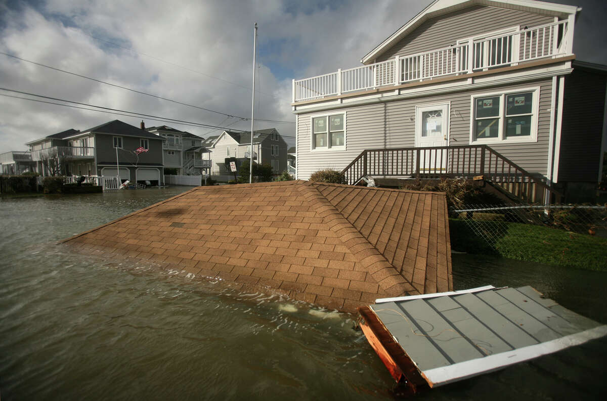 The roof from a garage destroyed by Hurricane Sandy floats at the intersection of Point Beach Drive and Elaine Road in Milford on Tuesday, October 30, 2012.