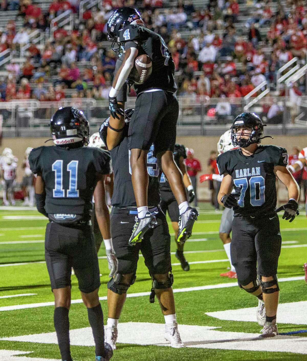 Harlan’s Payton Matthews is lifted into the air Thursday night Nov. 3, 2022 at Farris Stadium after scoring a touchdown during the first half of the Hawks’ game against the Taft Raiders.