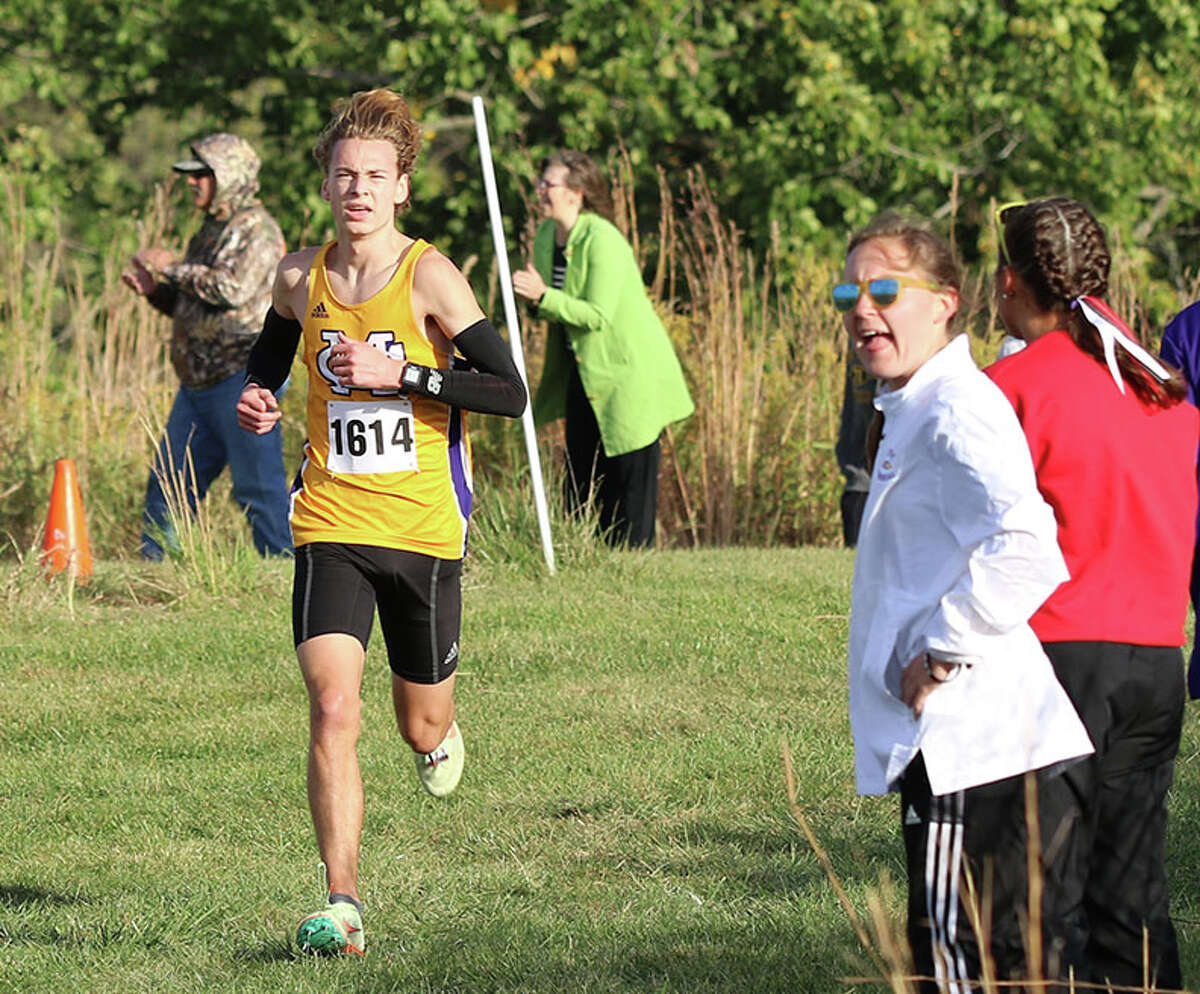 CM senior Jackson Collman (left) gets encouragement from CM senior Hannah Meiser, who looks to the leader Collman chases during his runner-up finish in the MVC Meet last month in Elsah. Both Collman and Meiser will be running for all-state honors in state races Saturday in Peoria.