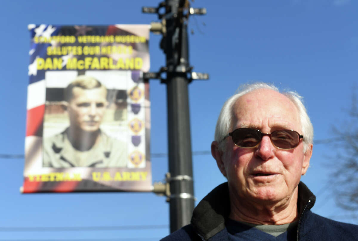 U.S. Army veteran Daniel McFarland, of Stratford, poses in front of his banner currently on display with others along Main St. in Stratford, Conn. Nov. 3, 2022. McFarland served in the Army during the Vietnam War.