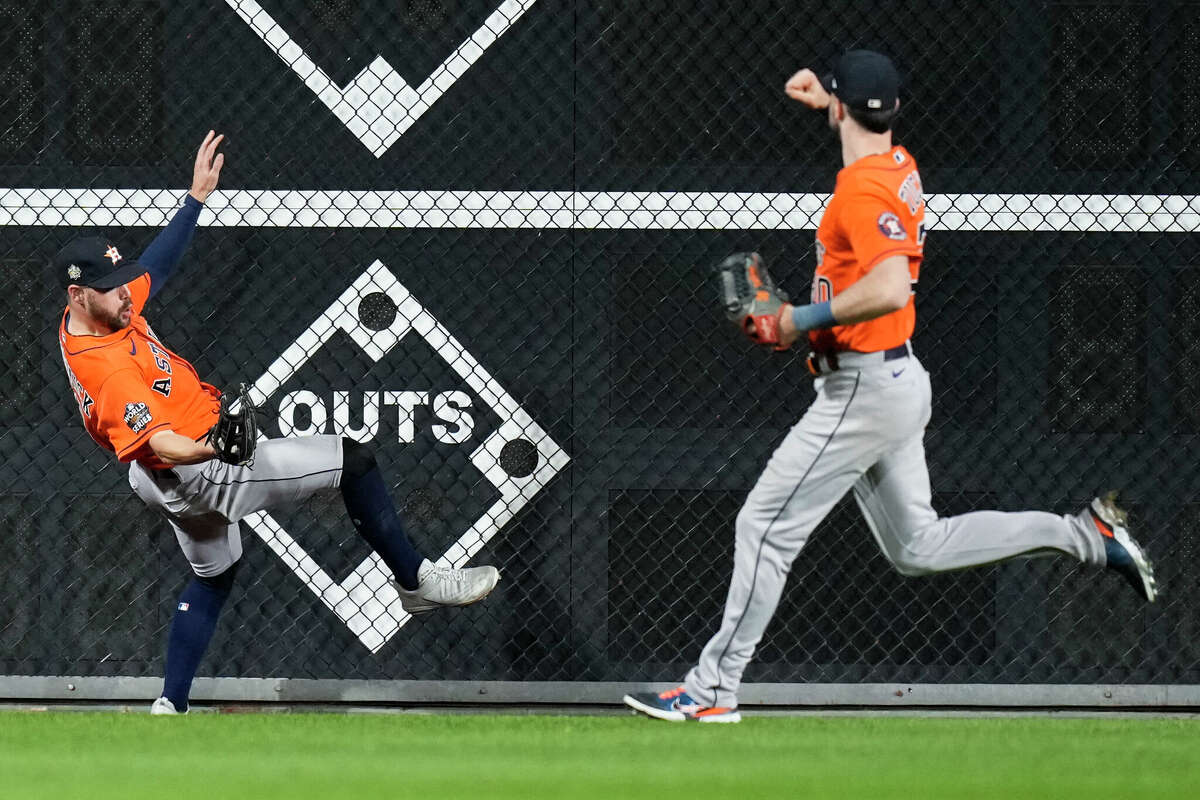 Houston Astros Chas McCormick (20) fall to the ground beside right fielder Kyle Tucker after making a leaping catch against Philadelphia Phillies J.T. Realmuto in the ninth inning during Game 5 of the World Series at Citizens Bank Park on Thursday, Nov. 3, 2022, in Philadelphia.