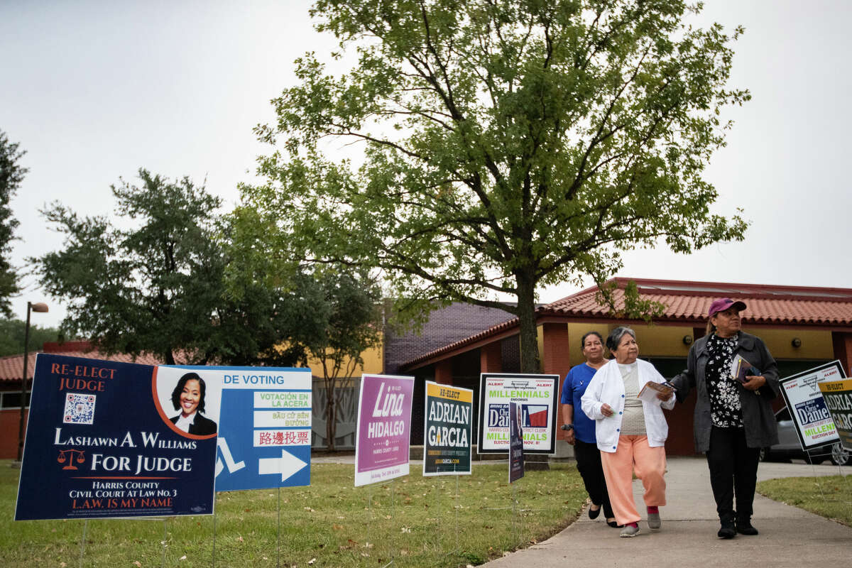 Maria Estrada, left, Carmen Hernández, center, 84, and Consuelo Ramírez, right, 57, return to their cars after taking  Hernández, to cast her vote in Moody Park, Thursday, Nov. 3, 2022, in Houston. Ramírez has spent years driving senior citizens like Hernández, wishing to cast their vote but unable to arrive to the polling sites alone.