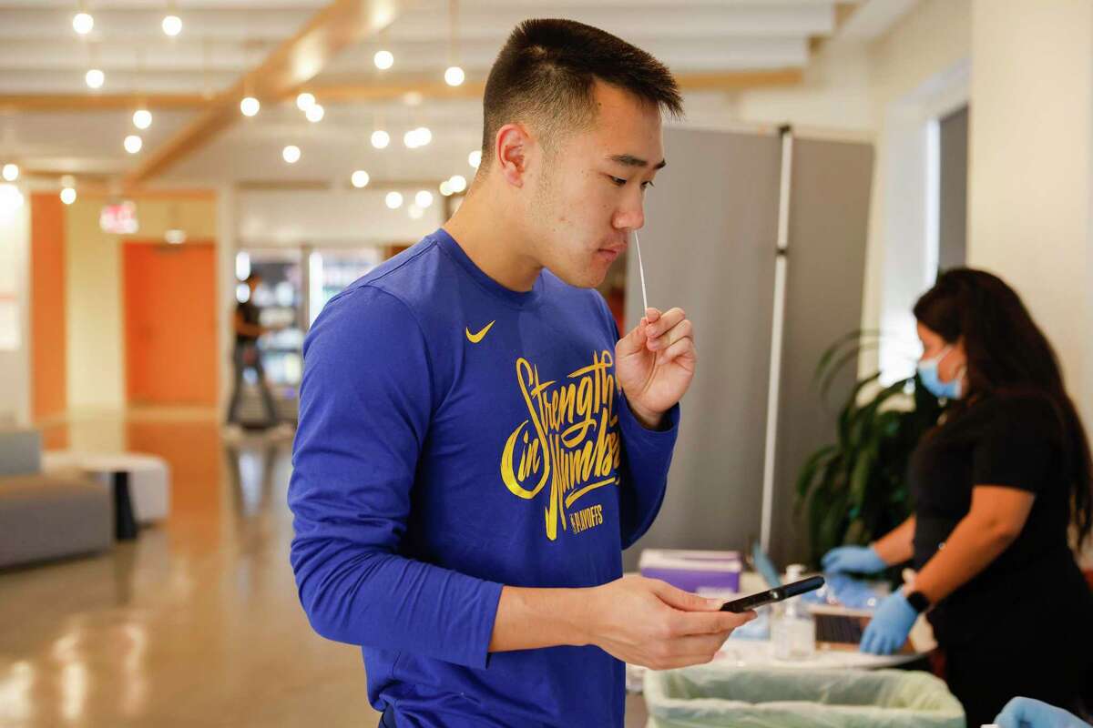 Cody Zeng takes a rapid antigen COVID-19 test at the in-house testing center at the DoorDash offices in San Francisco. Coronavirus infection rates have risen dramatically in just one month.