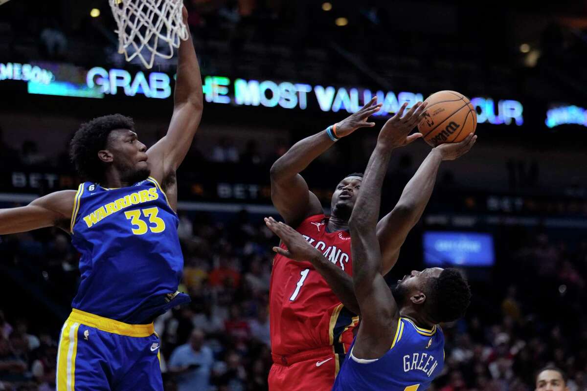 New Orleans Pelicans forward Zion Williamson (1) goes to the basket between Golden State Warriors center James Wiseman (33) and forward JaMychal Green (1) in New Orleans, Friday, Nov. 4, 2022.