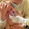 在这张资料照片中，明尼苏达州莱克维尔的梅雷迪思·勒格里。她抱着受惊的3岁儿子安德鲁(Andrew)，正在等待圣保罗儿童医院(Children’s Hospital of St. Paul)的RSV检测结果。安德鲁正在接受雾化治疗，以减轻呼吸道炎症，让他能更轻松地呼吸。