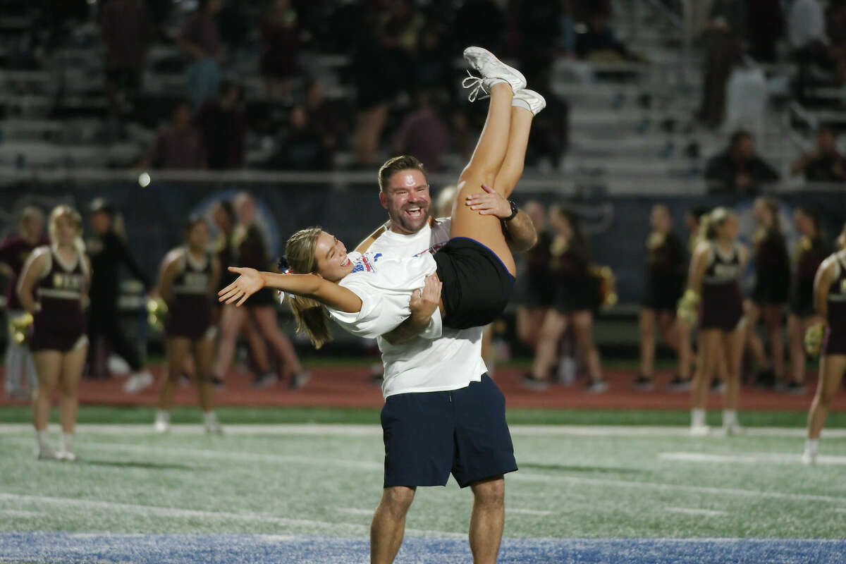 Dads perform with their daughters as the Friendswood cheerleaders are introduced before the game against Magnolia West Friday, Nov. 4, 2022 at Friendswood High School.