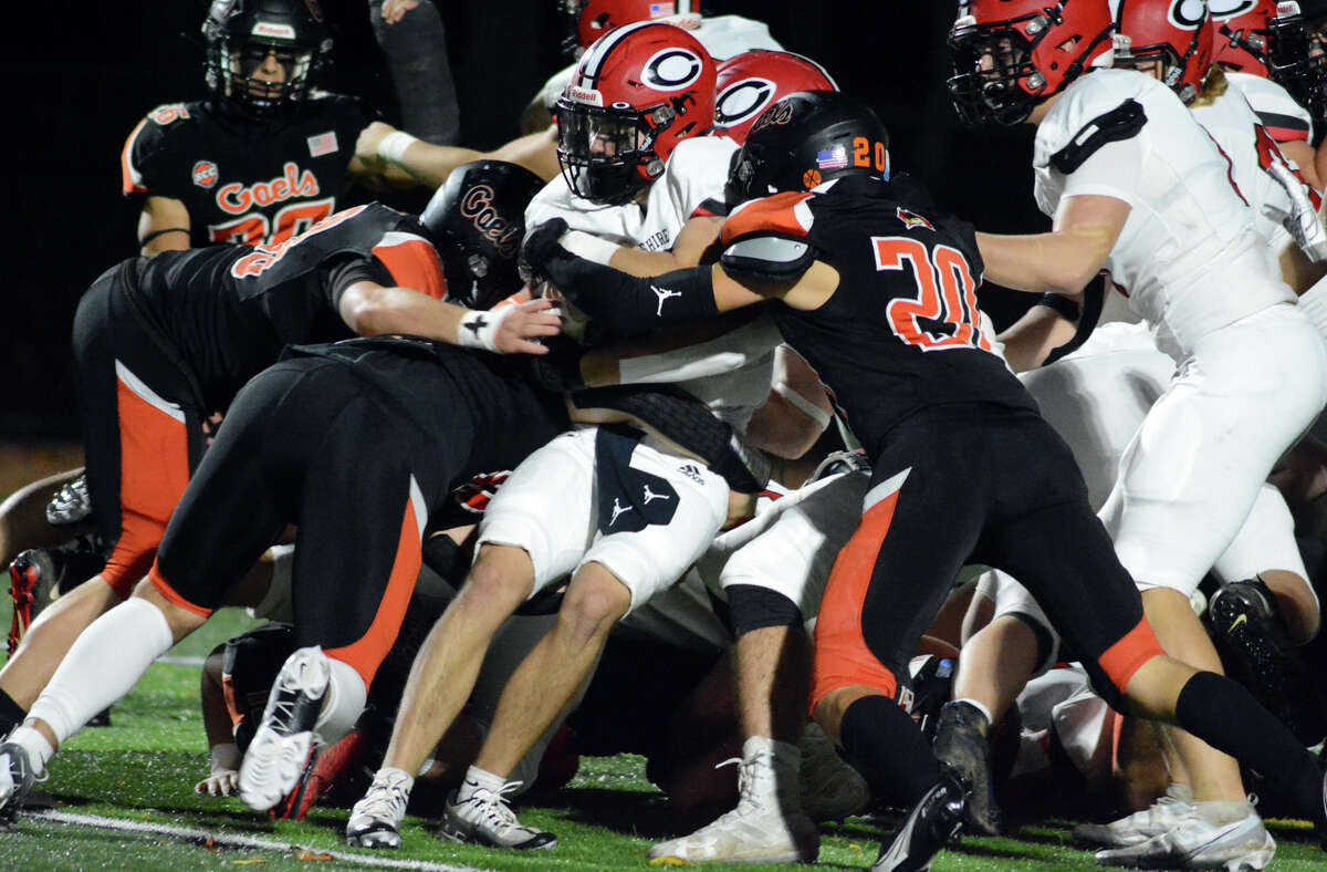 Cheshire's Michael Simeone is surrounded by a host of Shelton tacklers, including Logan Weiss (20) during the football game between Shelton and Cheshire on Friday, Nov. 4, 2022.
