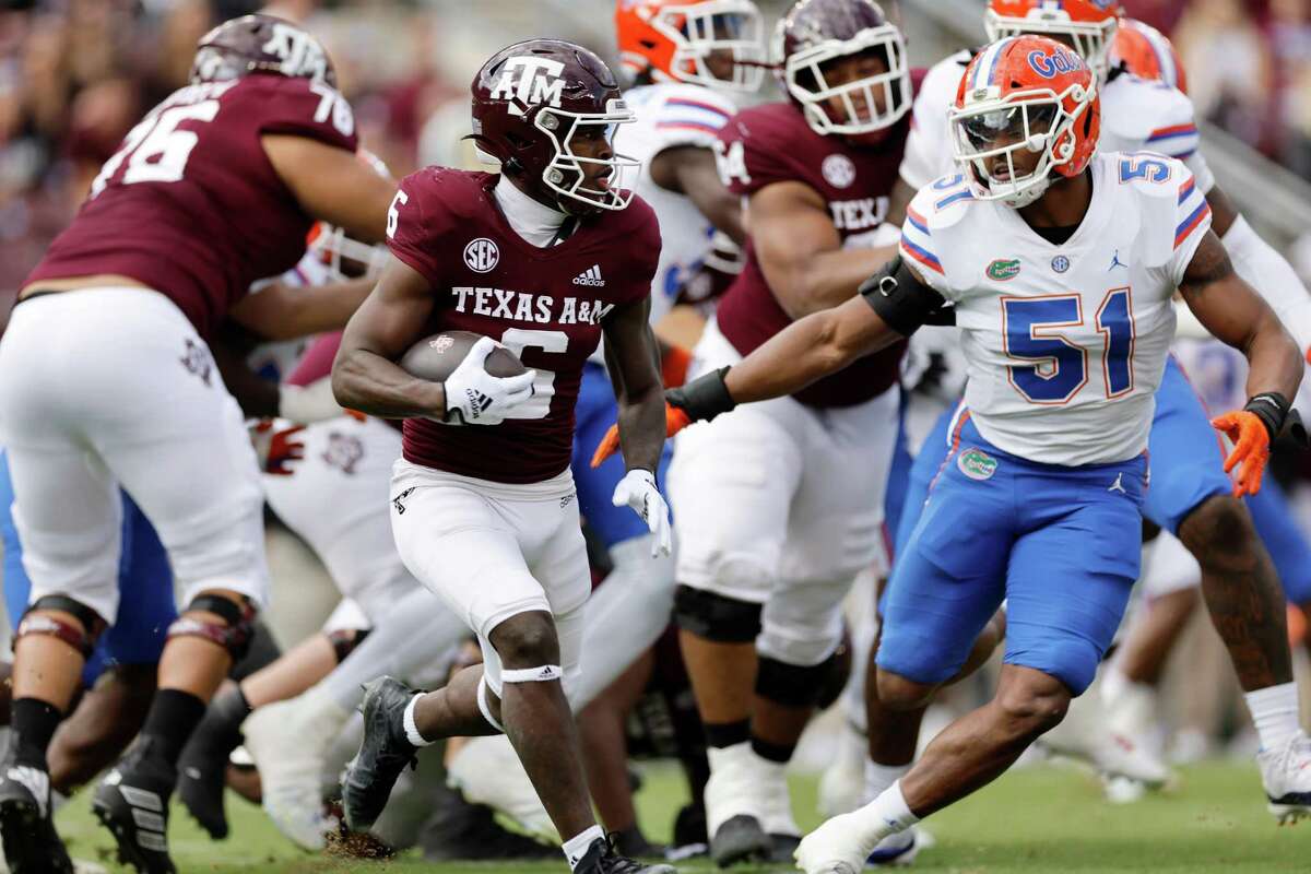 COLLEGE STATION, TEXAS - NOVEMBER 05: Devon Achane #6 of the Texas A&M Aggies runs the ball defended by Ventrell Miller #51 of the Florida Gators in the first quarter at Kyle Field on November 05, 2022 in College Station, Texas.