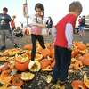 Children participate in a pumpkin smashing free for all before a composting demonstration at Captain's Cove Seaport in Bridgeport, Conn. on Saturday, November 5, 2022.