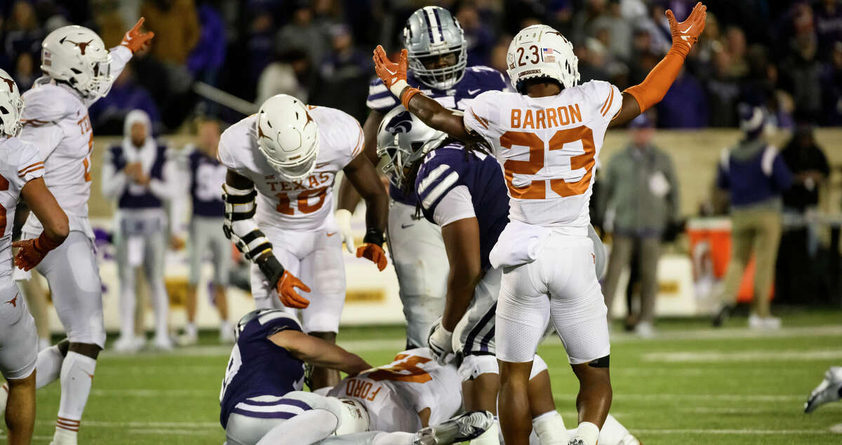 Texas defensive back Jahdae Barron (23) celebrates after Texas linebacker Jaylan Ford (41) recovers a fumble to end Kansas State's attempted comeback during the second half of an NCAA college football game Saturday, Nov. 5, 2022, in Manhattan, Kan. (AP Photo/Reed Hoffmann)