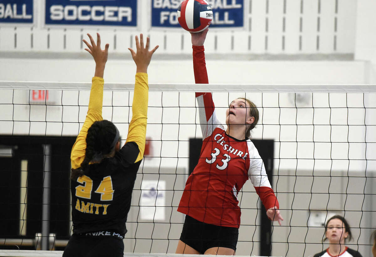 Chsehire's Eva Catalanotto (33) takes a shot while Amity's Nyleea Miller (24) attempts top block during the SCC girls volleyball final in West Haven on Saturday, Nov. 5, 2022.