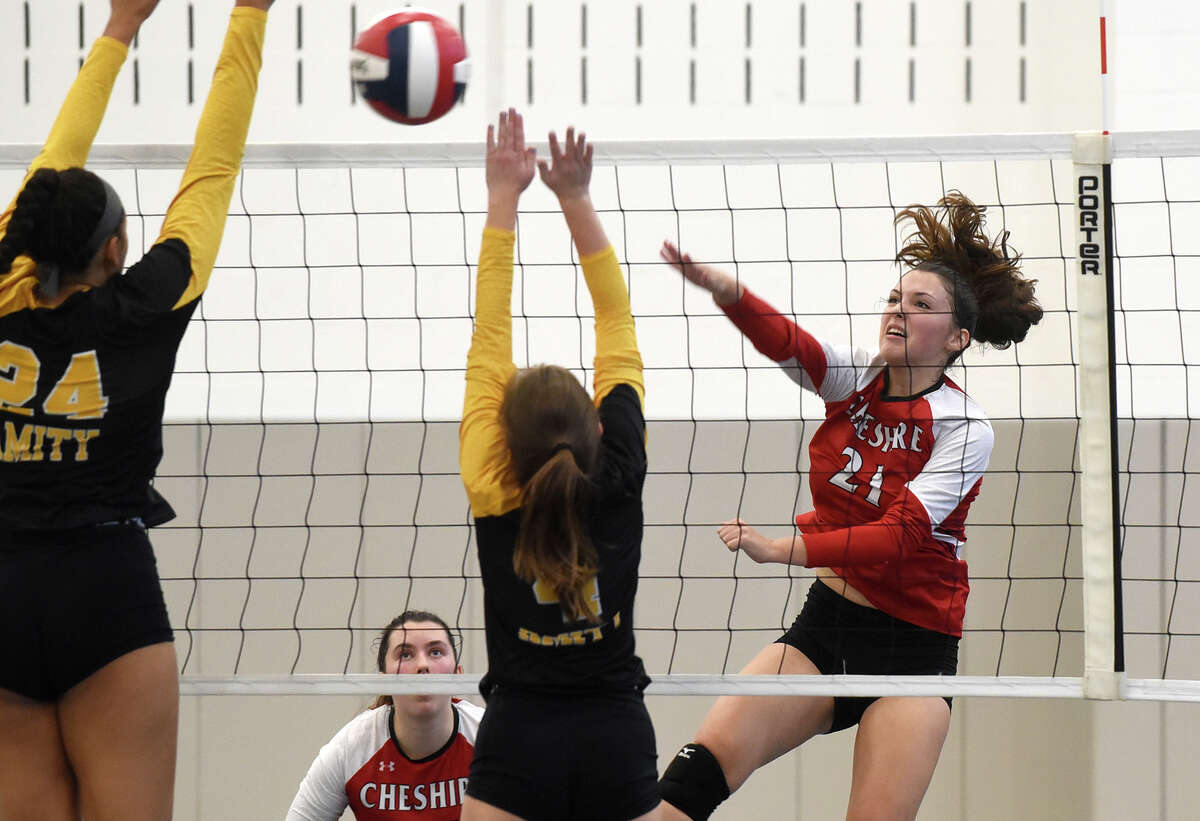 Cheshire's Avery Mola (21) takes a shot at Amity during the SCC girls volleyball final in West Haven on Saturday, Nov. 5, 2022.