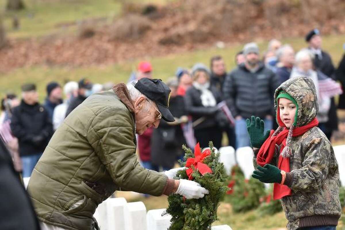 Art Williams, left, 98, helps a youngster law a wreath at a past event of Alton's Wreaths Across America ceremony at the Alton National Cemetery. Williams, a World War II veteran, will be 99 years old on Dec. 3. He has been laying wreaths for all 15 years of the Alton ceremony and will do so again this year for the 16th ceremony at 11 a.m. Saturday, Dec. 17. 