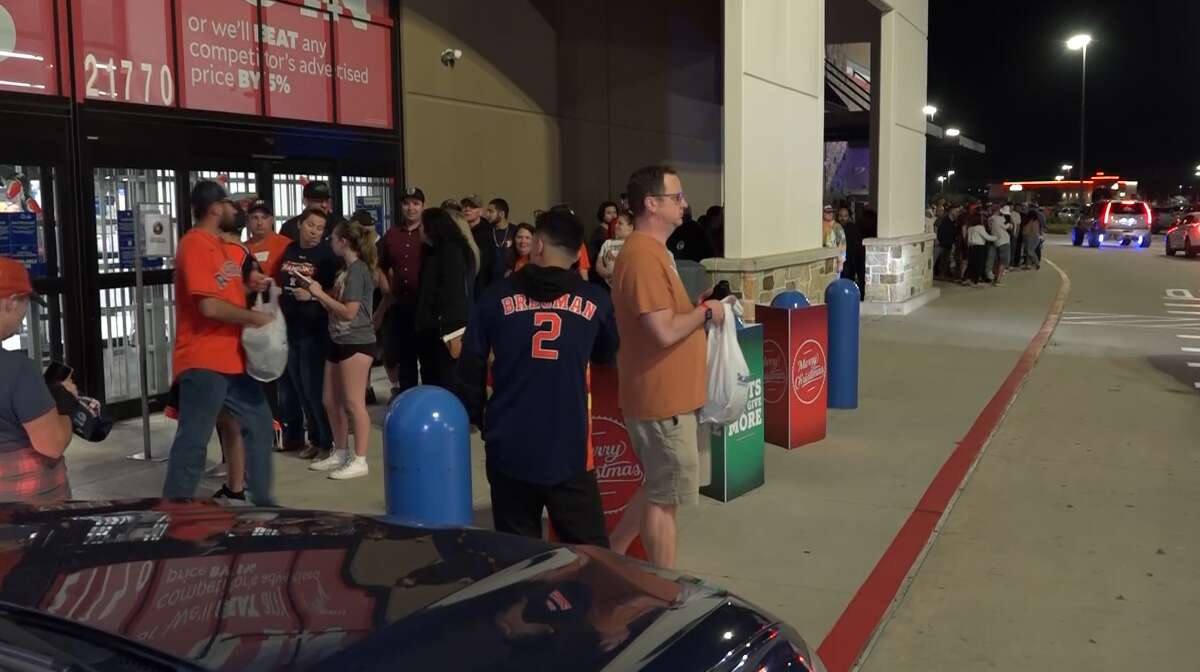 Astros fans form a line outside the Academy Sports + Outdoors in New Caney on Saturday night.
