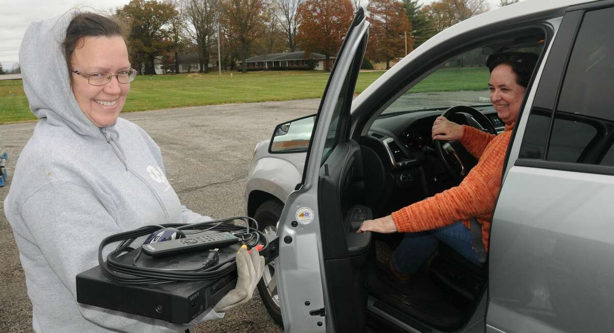 A CJD E-Cycling employee takes items from Karen Saale of Godfrey during Saturday's E-Waste Recycling Drive at Lewis and Clark Community College.     