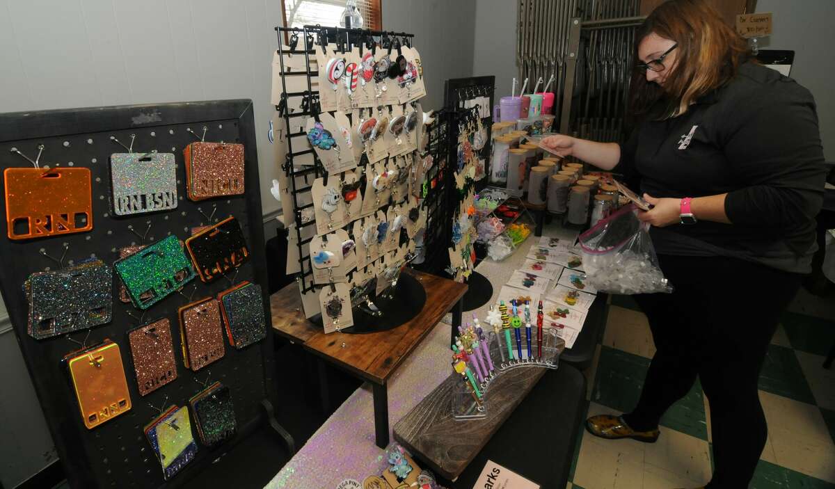 Jessica Akroyd of Bethalto puts out merchandise from her small business, Ambicide Designs, during Saturday's Vendor Craft Fair in Cottage Hills. 