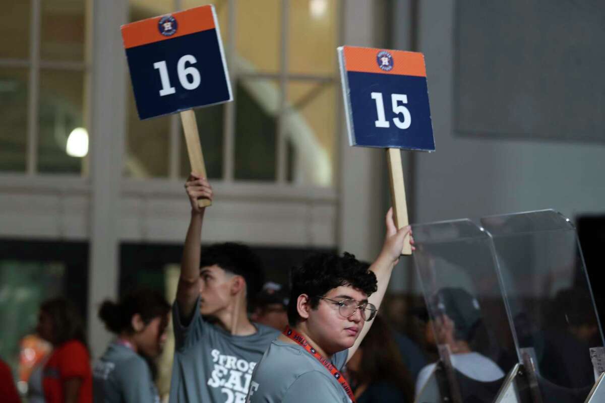 Workers hold up register numbers at checkout as fans flock to Minute Maid Park to purchase World Series apparel, Sunday, Nov. 6, 2022, in Houston.